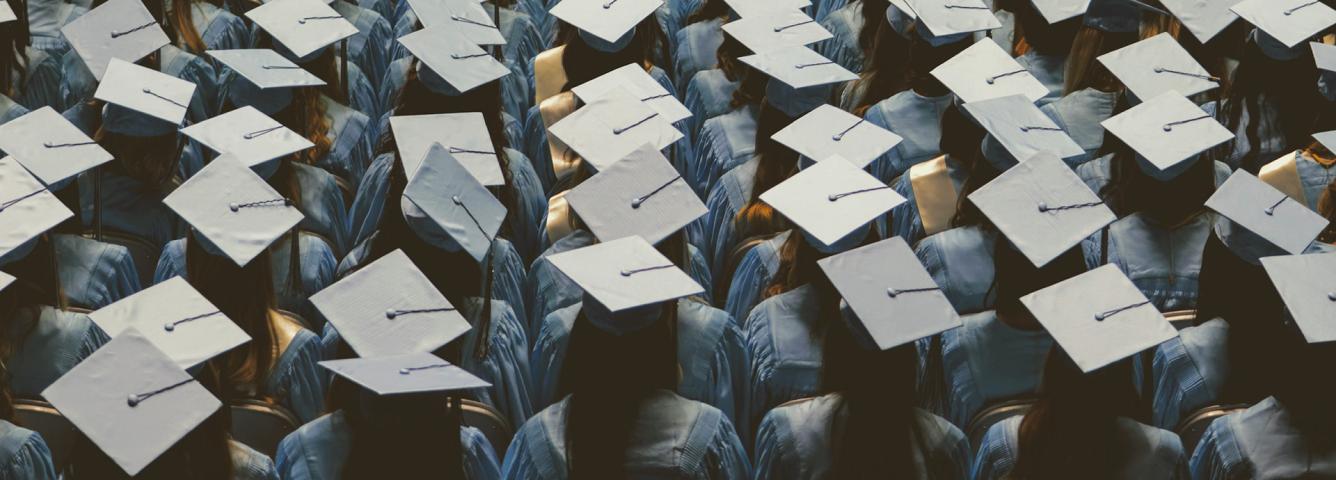 Many students wearing graduation caps in an audience