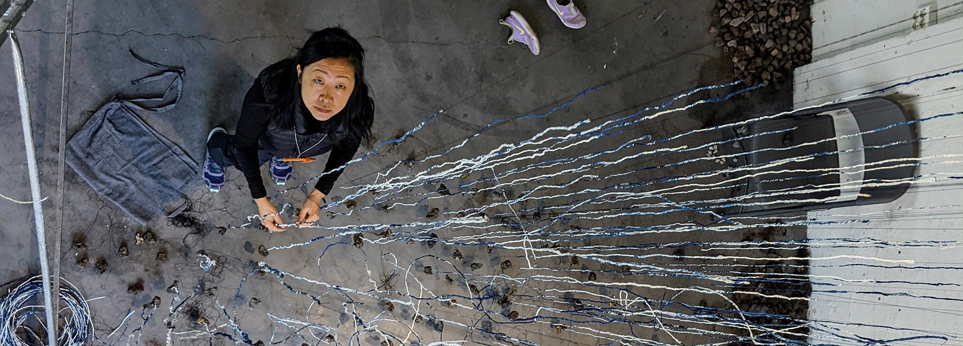 Beili Liu photographed from above while she is working on her art installation, Still Winds.