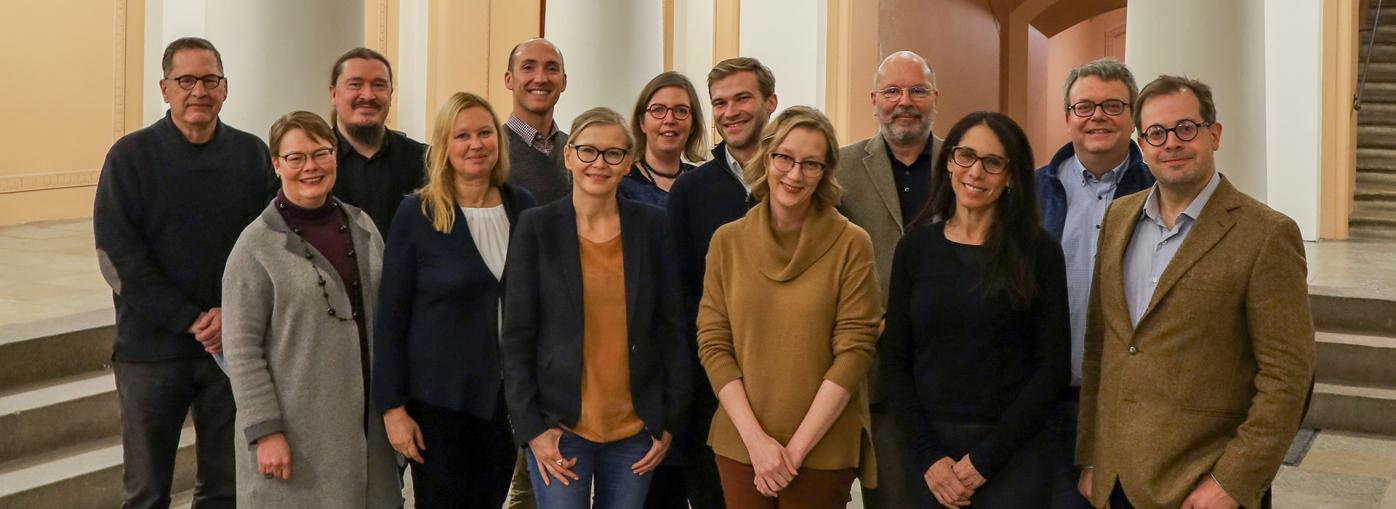 Leading scholars from Finland, the United States, the United Kingdom, and Germany in a group photo taken at the lobby of the main building of the University of Helsinki.