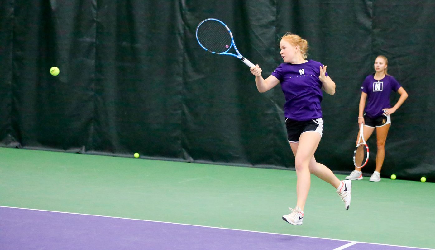 Aino Alkio playing tennis wearing purple Northwestern t-shirt.