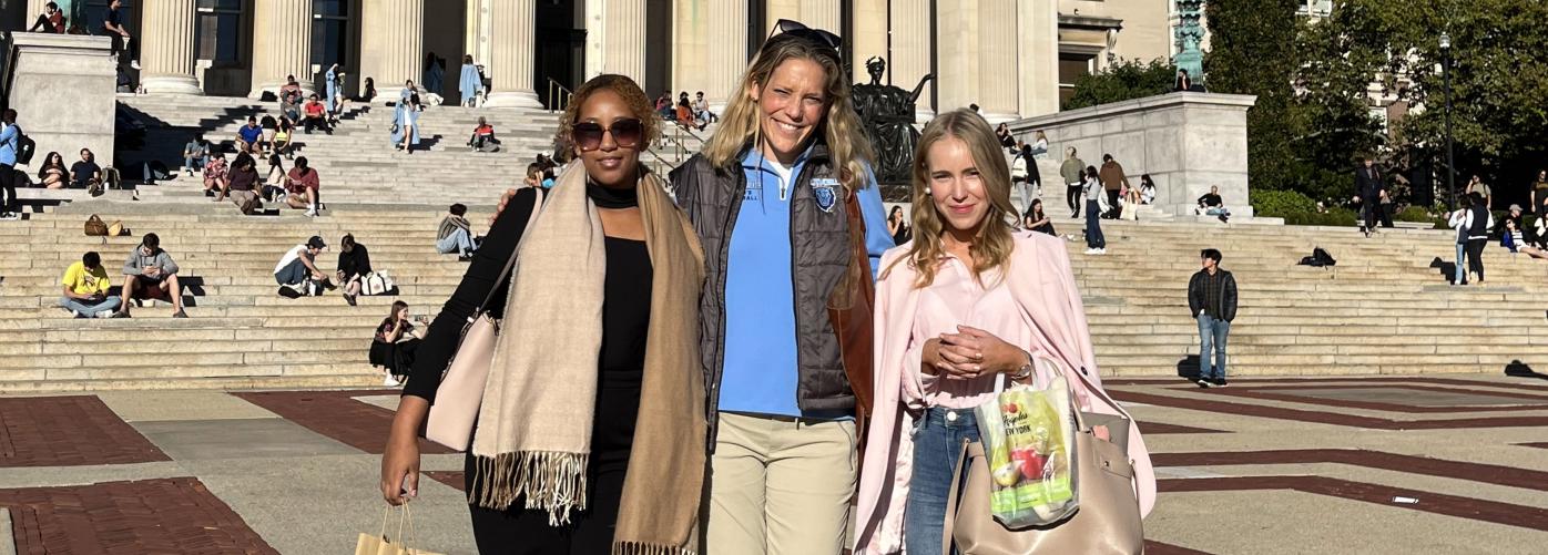 Helen Kesete, Jessica De Palo and Vivian Stolt smiling at the camera in front of a big building in New York City.