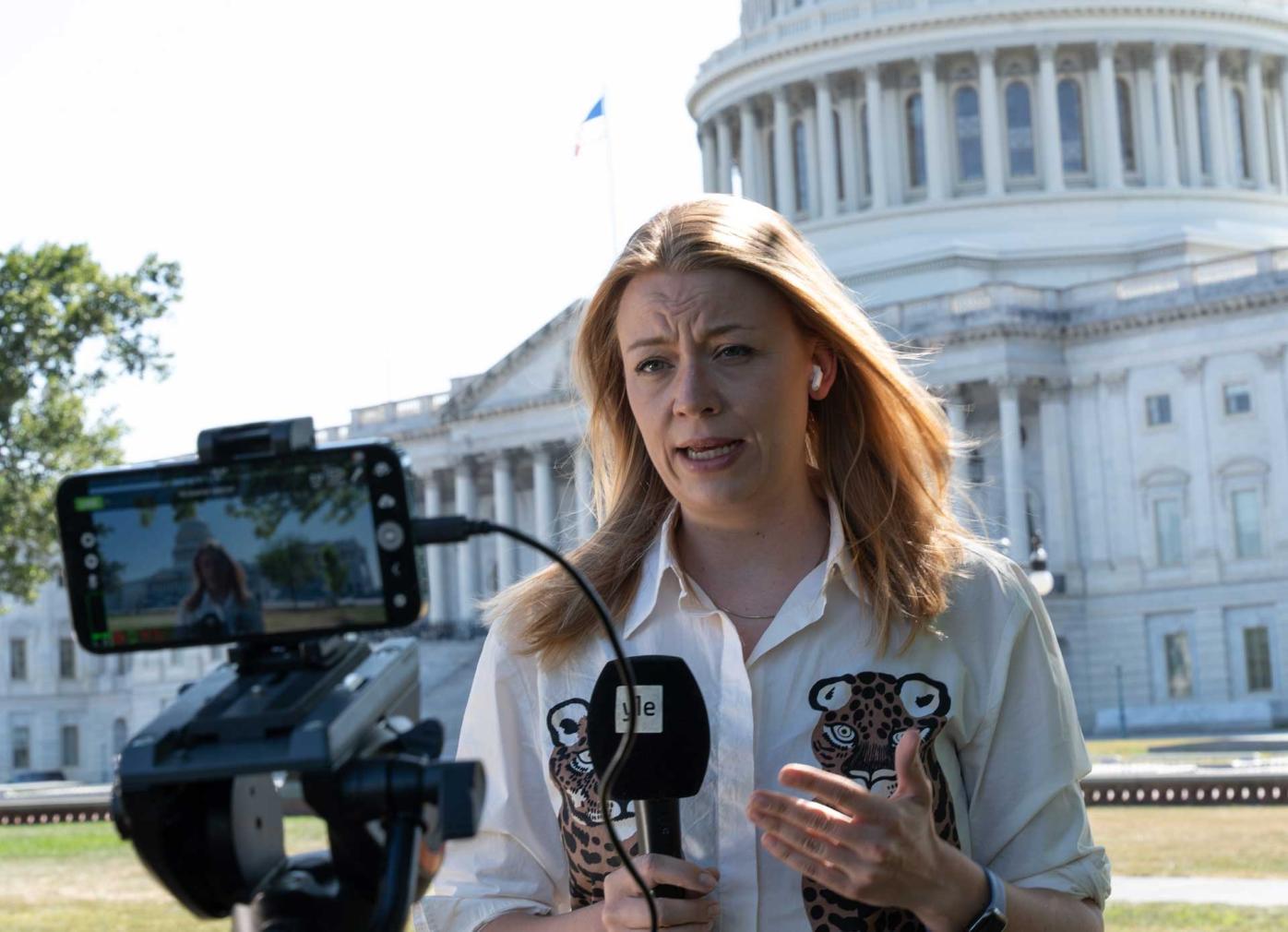 Iida Tikka reporting from the Capitol Hill. She is talking to a phone recording her report.