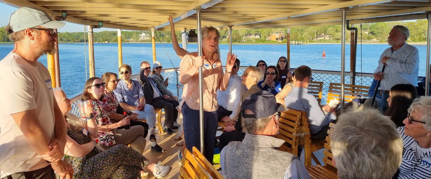 People on Steamboat Sabino at the Mystic River in Mystic, CT. In the middle of the photo there is a person telling something to the other people who are listening.