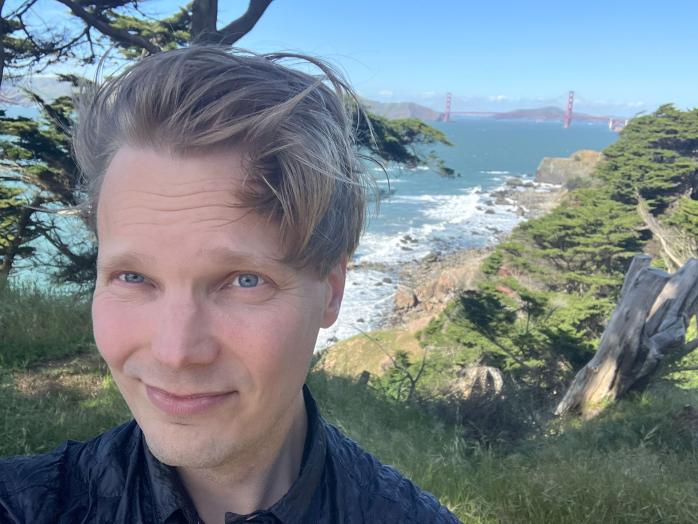 Selfie of Heikki Hietala taken on a sunny day in San Fransisco, with Golden Gate visible in the background.