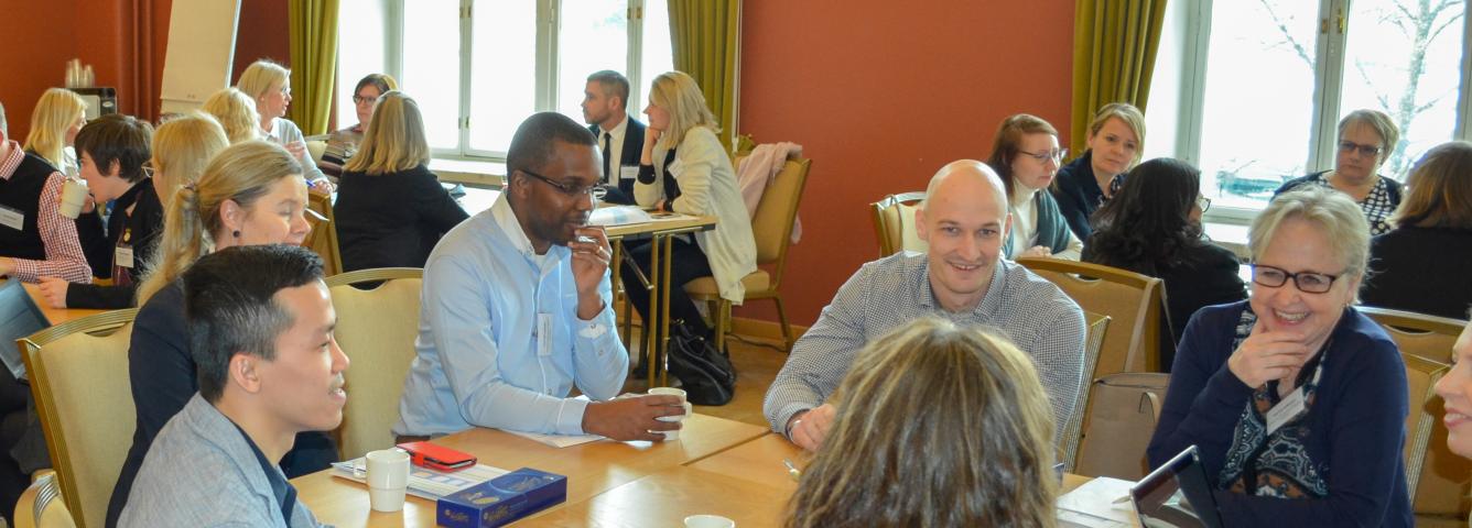 Workshop participants discussing and smiling in a small group