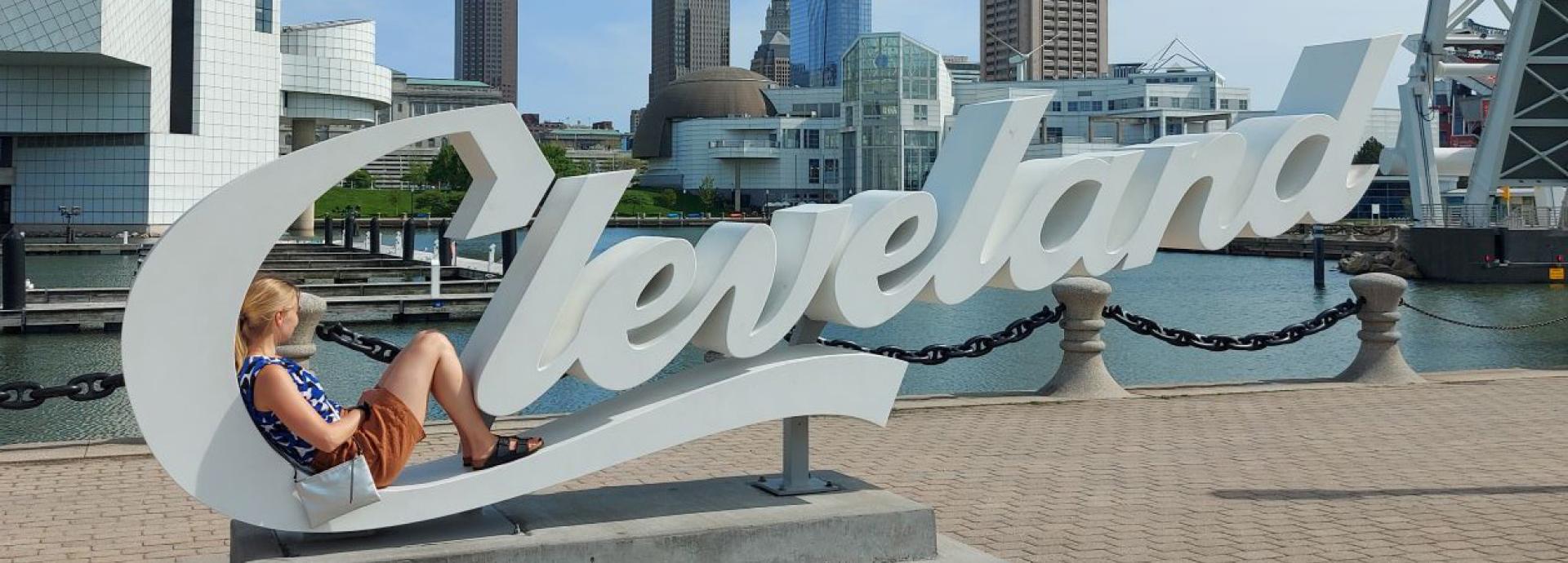 A woman sitting in the letter C in a Cleveland sign