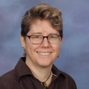 Photo of a smiling woman in a brown shirt