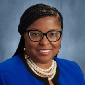 Photo of a woman in a blue suit jacket smiling at the camera