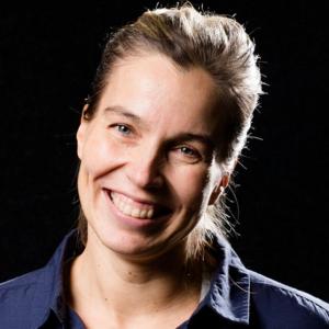 Person in a blue shirt in front of a black background